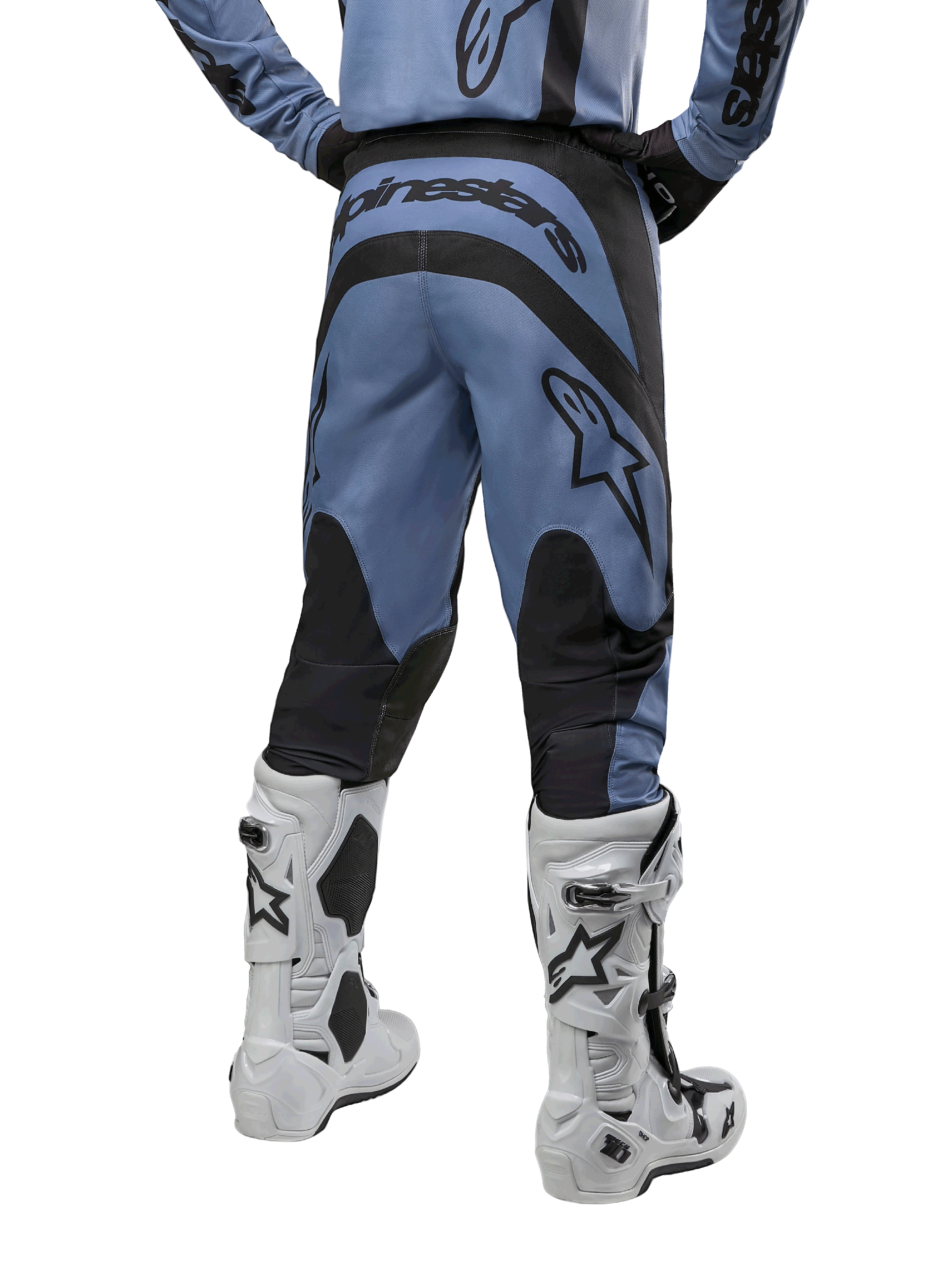 Alpinestars 2024 Fluid Lurv Pants, pantaloni da motocross, azzurro e nero, vista posteriore che mostra pannelli rinforzati neri e un grande logo del marchio, abbinati a stivali da motocross bianchi e neri, equipaggiamento professionale per fuoristrada