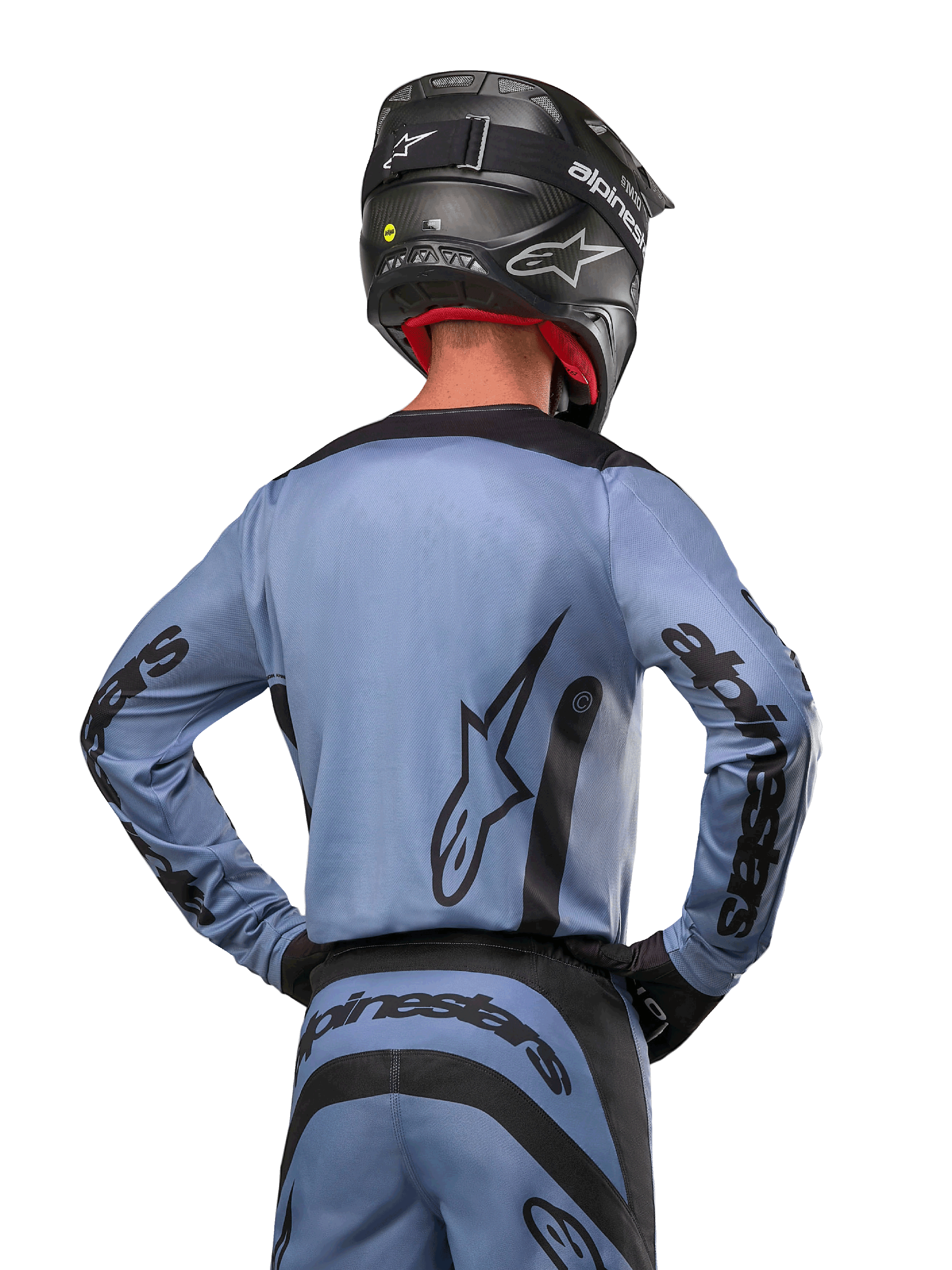 Alpinestars 2024 Fluid Lurv Jersey, maglia da motocross, azzurro e nero, vista posteriore del pilota che mostra il grande logo a stella e il branding sulle maniche, indossata con casco nero e pantaloni da fuoristrada coordinati, abbigliamento racing professionale