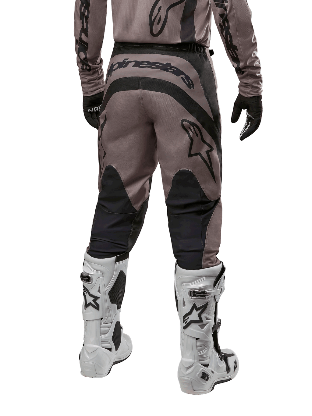 Alpinestars 2024 Fluid Lurv Pants, pantaloni da motocross, Mud Black, vista posteriore con grande logo Alpinestars nero sulla seduta e pannelli neri sui polpacci, indossati con stivali da motocross bianchi e neri e maglia coordinata