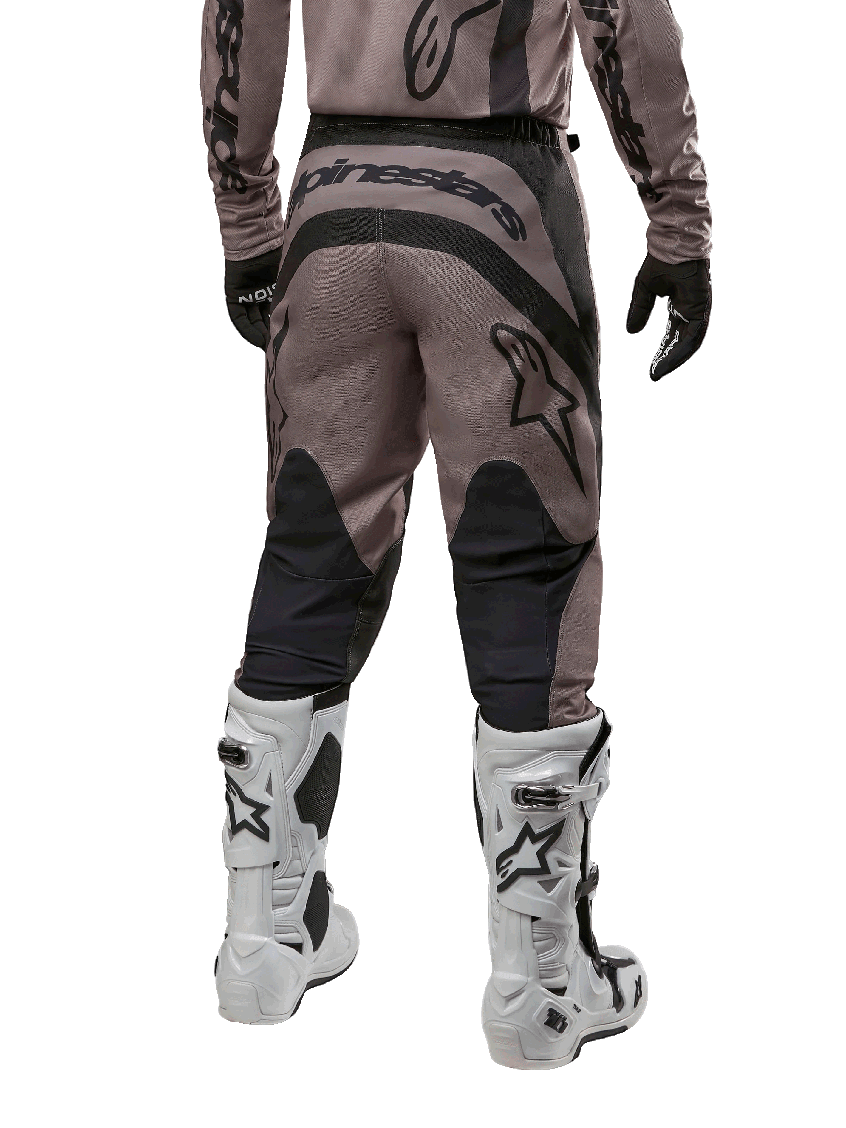 Alpinestars 2024 Fluid Lurv Pants, pantaloni da motocross, Mud Black, vista posteriore con grande logo Alpinestars nero sulla seduta e pannelli neri sui polpacci, indossati con stivali da motocross bianchi e neri e maglia coordinata