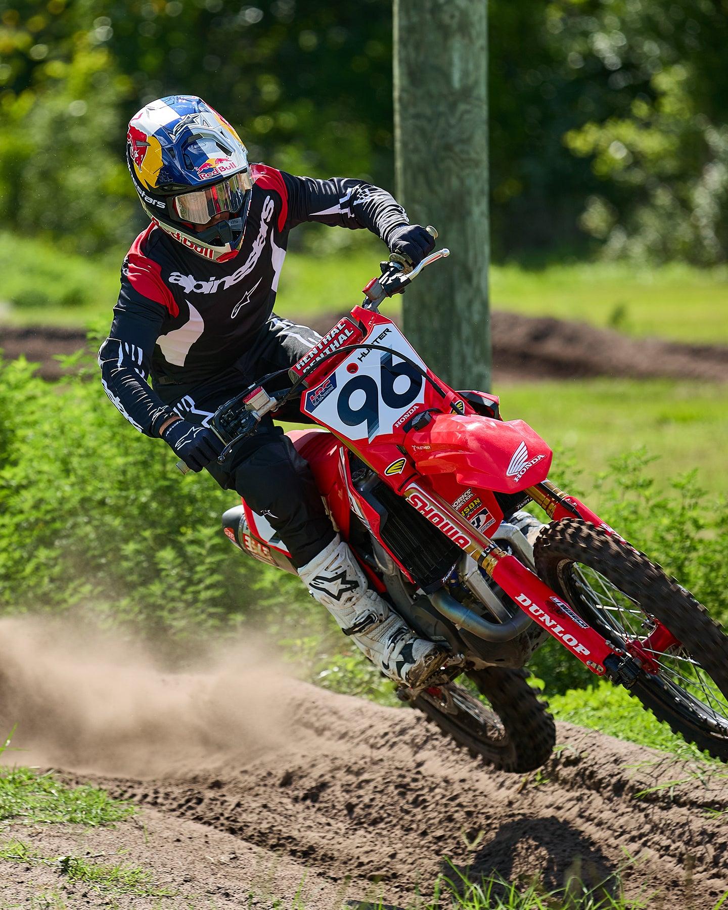 Alpinestars Completo Fluid Haul 2025, maglia e pantaloni motocross neri e bianchi, pilota numero 96 su moto Honda rossa.