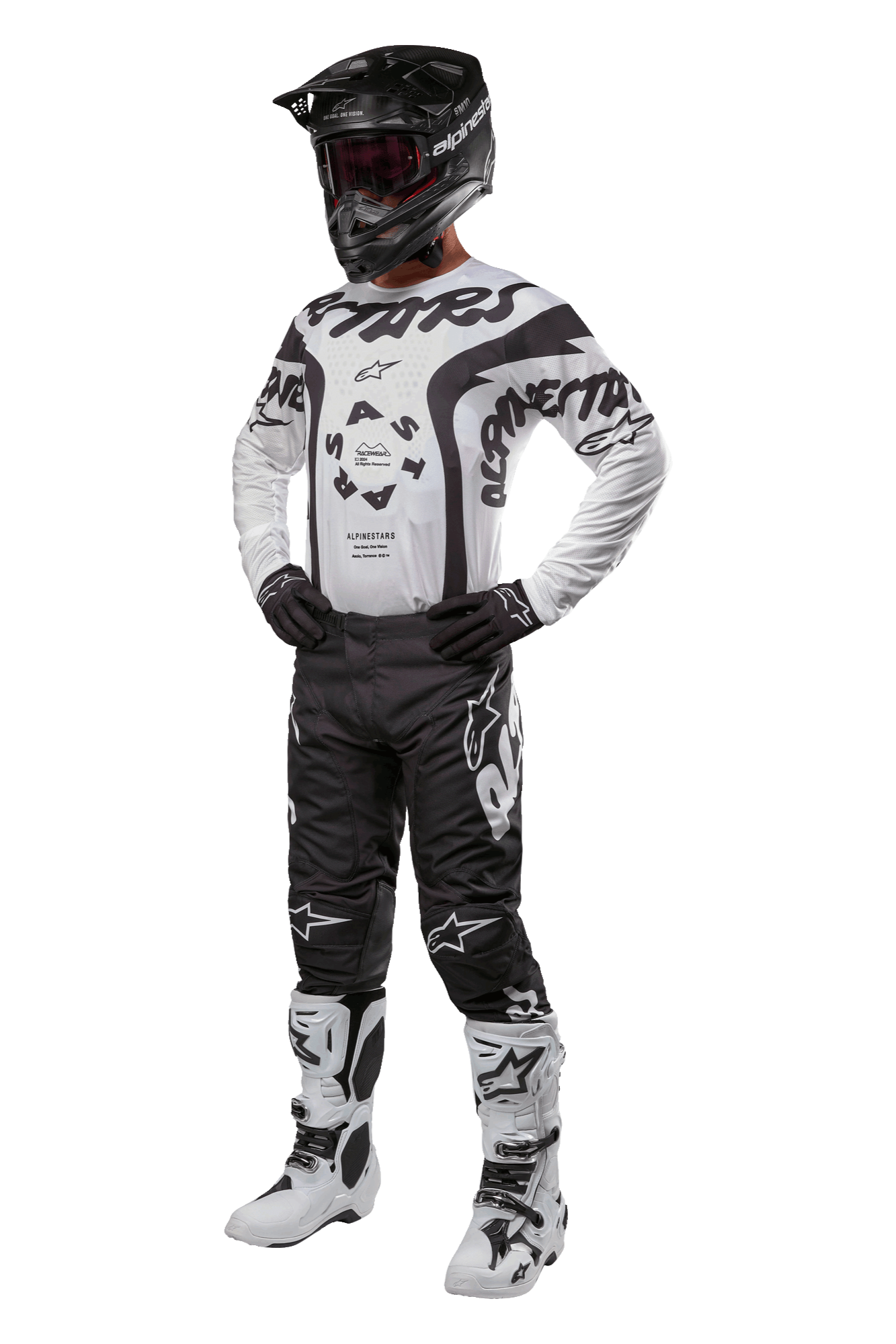 Alpinestars 2024 Racer Hana Pants, pantaloni da motocross neri con loghi bianchi, indossati come parte di un completo con maglia coordinata bianca e nera, casco nero e stivali bianchi, abbigliamento protettivo per fuoristrada
