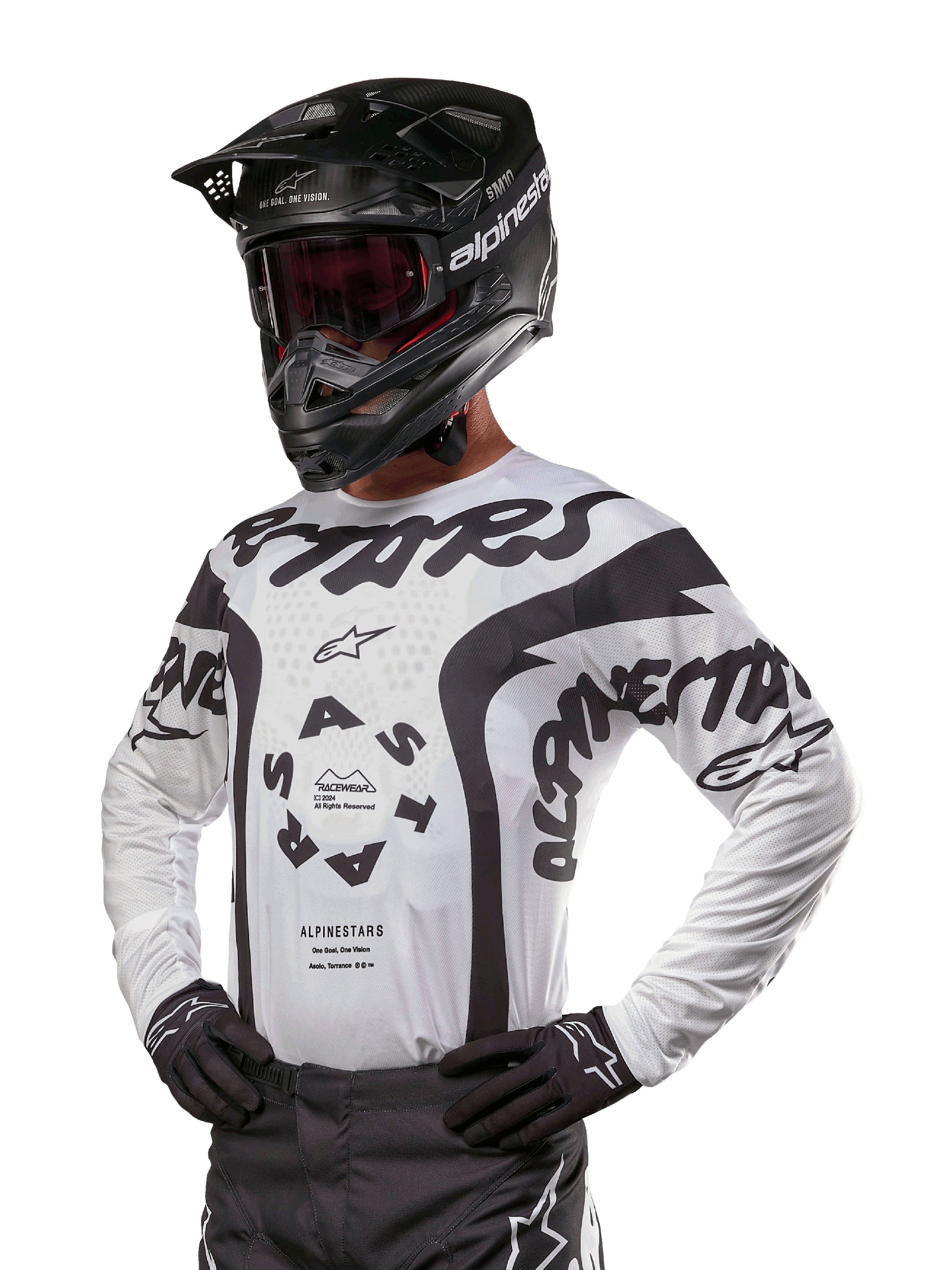 Alpinestars 2024 Racer Hana Jersey, maglia da motocross, bianca e nera, grafiche audaci con branding Alpinestars e Astars, indossata con casco nero e guanti neri, equipaggiamento tecnico da motocross fuoristrada