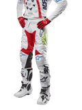 Pantaloni Alpinestars Racer Hana 2024, pantaloni da motocross, bianco con accenti rosso, blu e verde lime, design protettivo con pannelli in pelle sulle ginocchia, abbinati a maglia coordinata, guanti rossi e stivali bianchi con fibbie, outfit sportivo da motocross