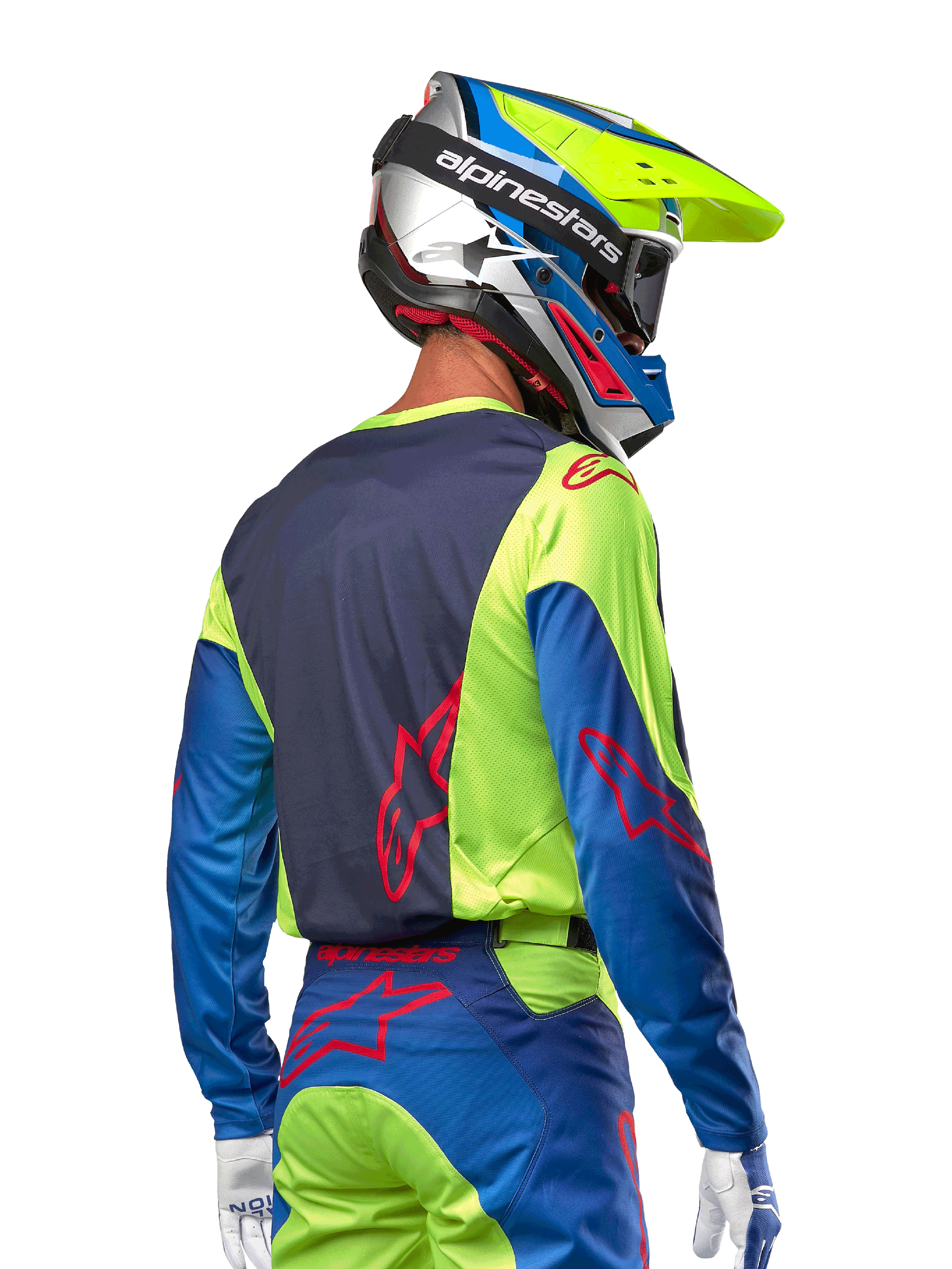 Pilota di motocross che indossa la maglia Alpinestars 2024 Racer Hoen in giallo fluo e blu night navy, con logo a stella rosso sulla schiena, pantaloni da motocross abbinati e casco da gara coordinato, vista posteriore che mette in risalto il design ergonomico per prestazioni fuoristrada.
