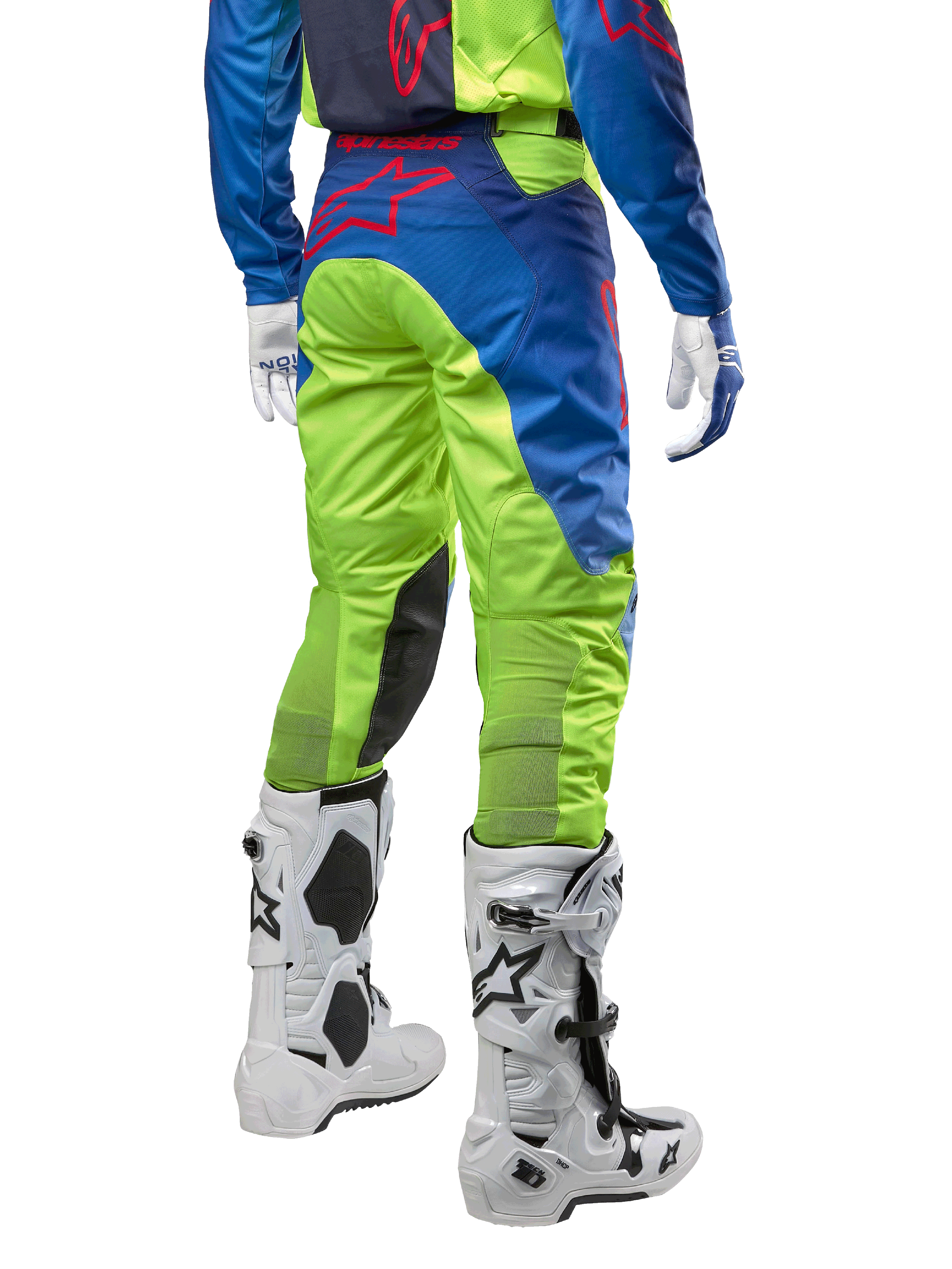 Pantaloni Alpinestars Racer Hoen 2024, pantaloni da motocross, giallo fluo e blu Night Navy, vista posteriore, con logo Alpinestars rosso, indossati con maglia coordinata, guanti bianchi e stivali da motocross bianchi, tessuto resistente per corse off-road