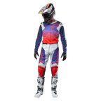 Alpinestars 2024 Racer Hoen Pants, pantaloni da motocross grigio chiaro con accenti arancioni e blu, indossati con maglia sfumata coordinata, casco, guanti neri e stivali bianchi, equipaggiamento protettivo completo