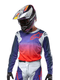 Alpinestars Maglia Racer Hoen 2024, maglia da motocross, gradiente viola e arancione acceso con maniche blu scuro, inserti grigio chiaro sulle spalle, indossata con pantaloni da corsa e casco coordinati, abbigliamento completo da fuoristrada