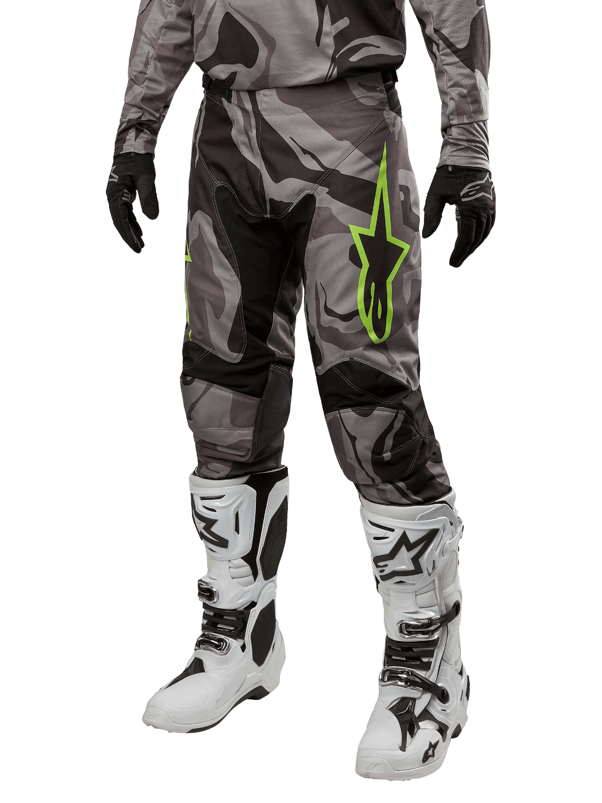 Alpinestars 2024 Racer Tactical Pants, pantaloni da motocross, pattern mimetico grigio e nero, logo a stella verde lime, indossati con stivali bianchi e neri e guanti neri, equipaggiamento per guida off-road