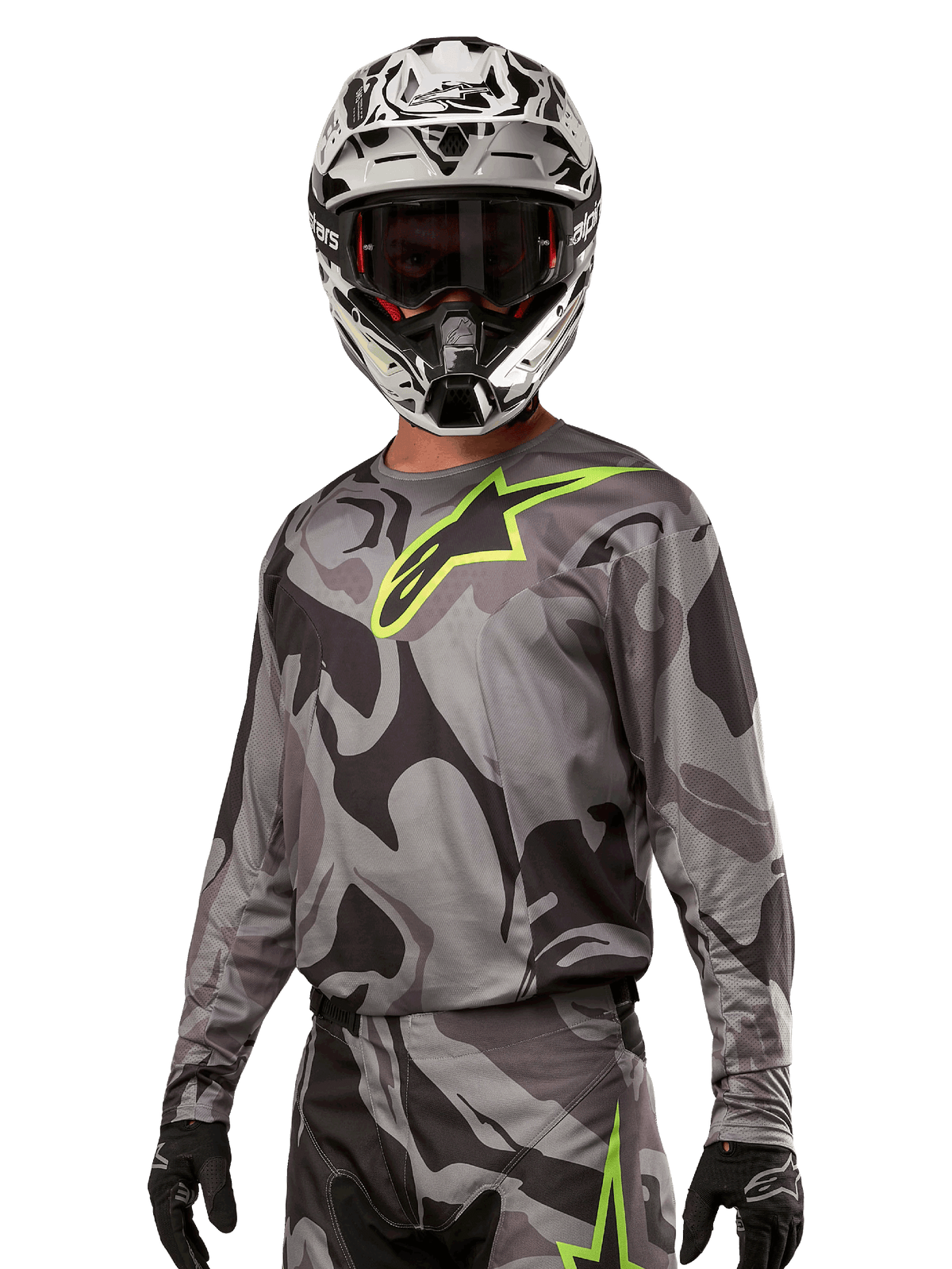 Alpinestars 2024 Racer Tactical Jersey, maglia da motocross, mimetico grigio con logo verde neon, indossata con casco bianco e nero e guanti neri, tessuto tecnico traspirante per gare fuoristrada