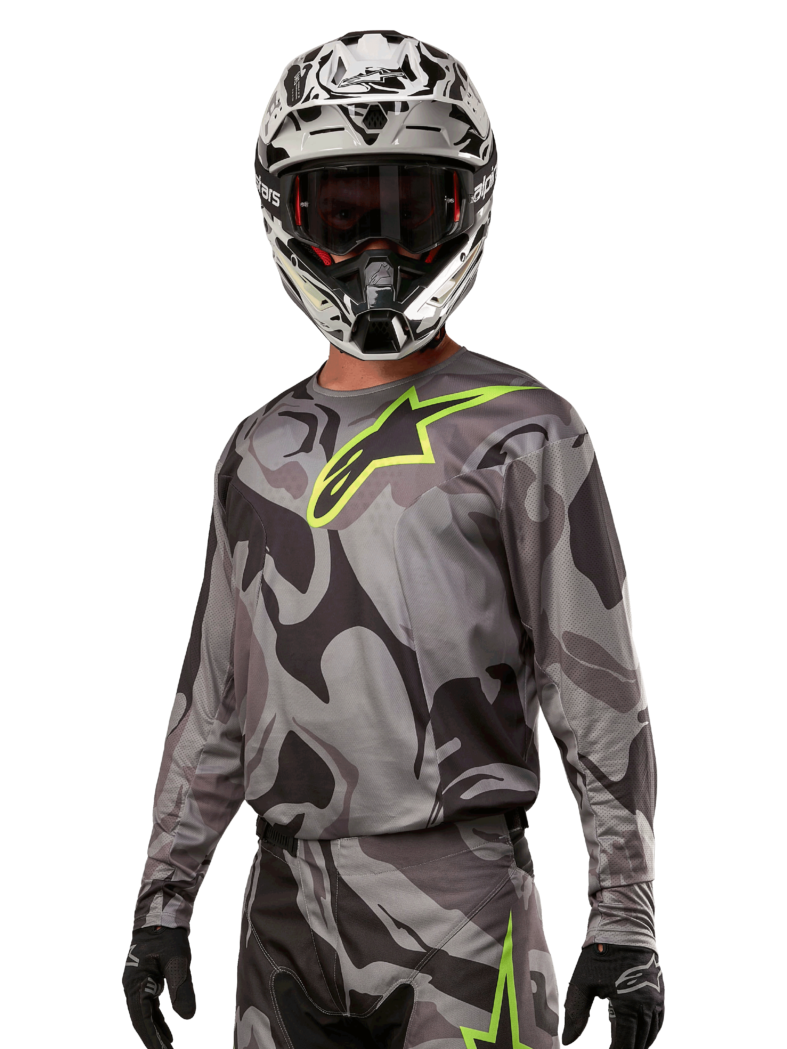 Alpinestars 2024 Racer Tactical Jersey, maglia da motocross, mimetico grigio con logo verde neon, indossata con casco bianco e nero e guanti neri, tessuto tecnico traspirante per gare fuoristrada