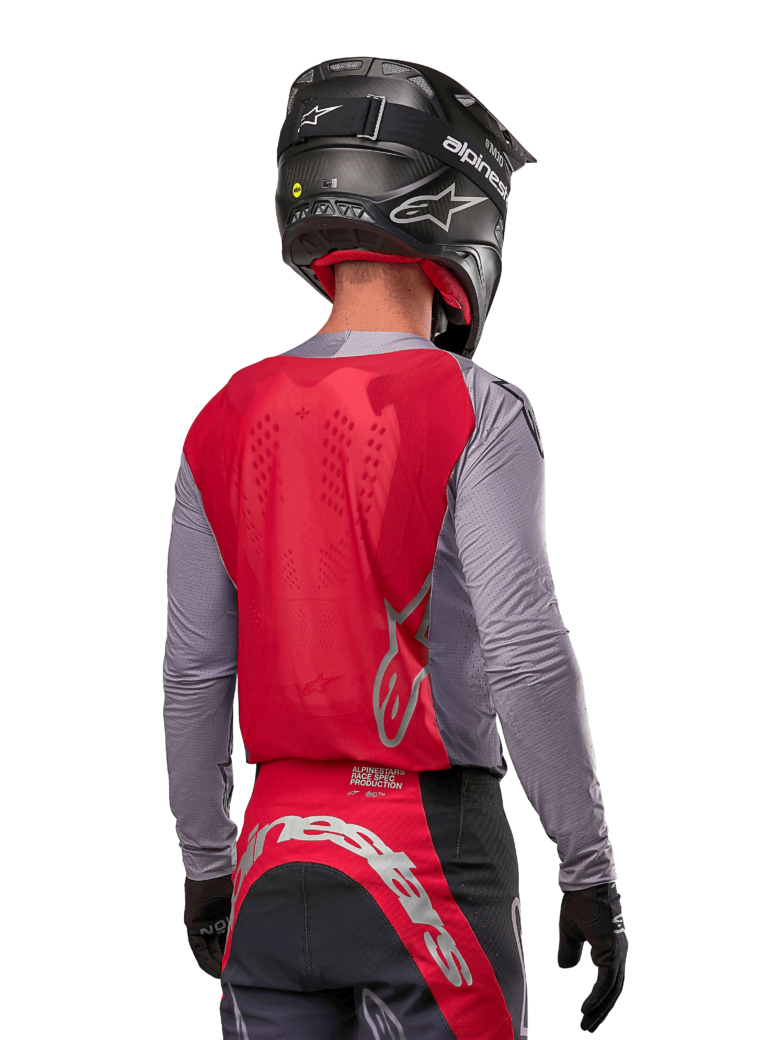 Pilota di motocross visto da dietro che indossa la maglia Alpinestars Supertech Dade 2024 in Iron Red Berry e grigio, con pannello posteriore in mesh traspirante e dettagli del logo in argento, abbinata a un casco nero e pantaloni da corsa coordinati per prestazioni off-road professionali.