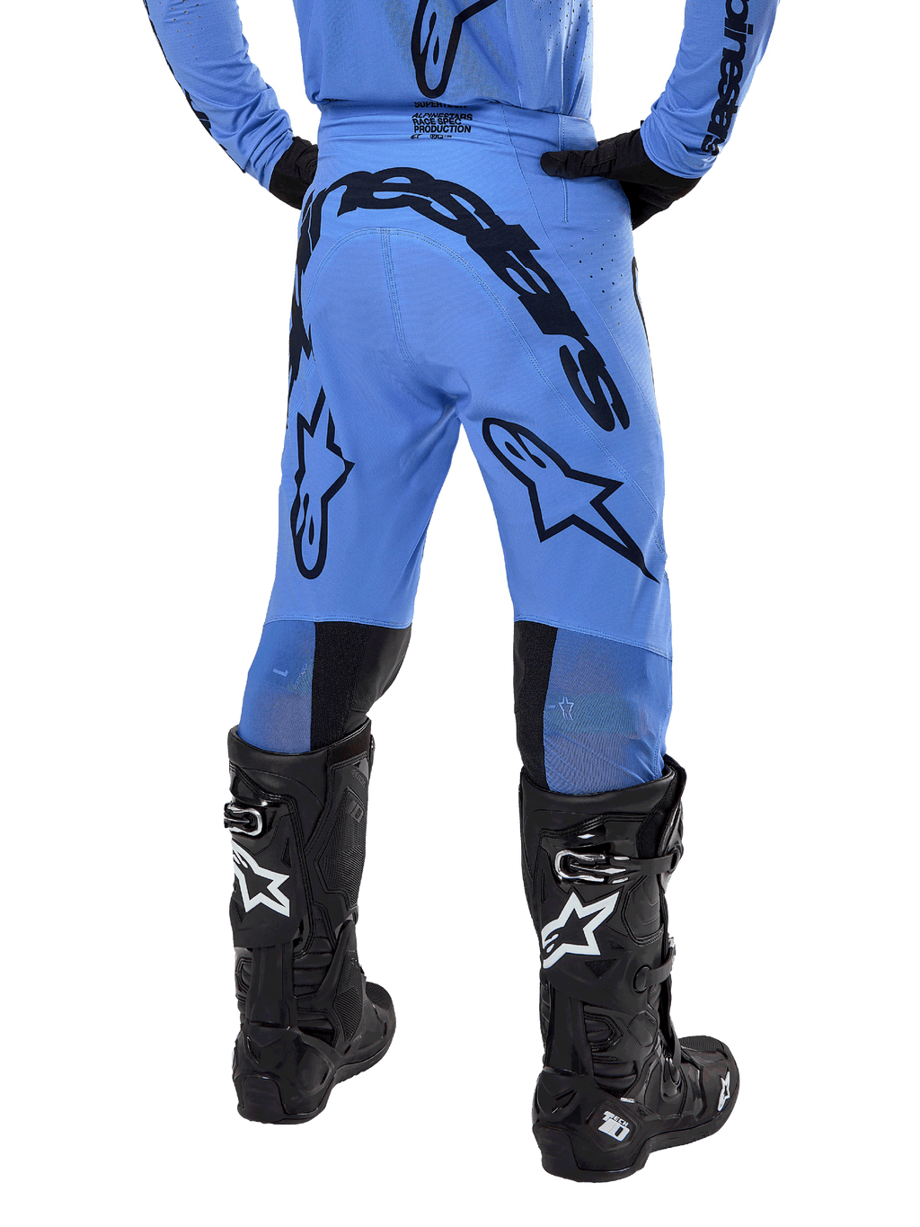 Pantaloni Alpinestars Supertech Dade 2024, pantaloni da motocross, blu chiaro, vista posteriore con grande marchio nero sulla seduta e sulle gambe, indossati con stivali neri Alpinestars Tech 10, vestibilità racing atletica per prestazioni professionali fuoristrada