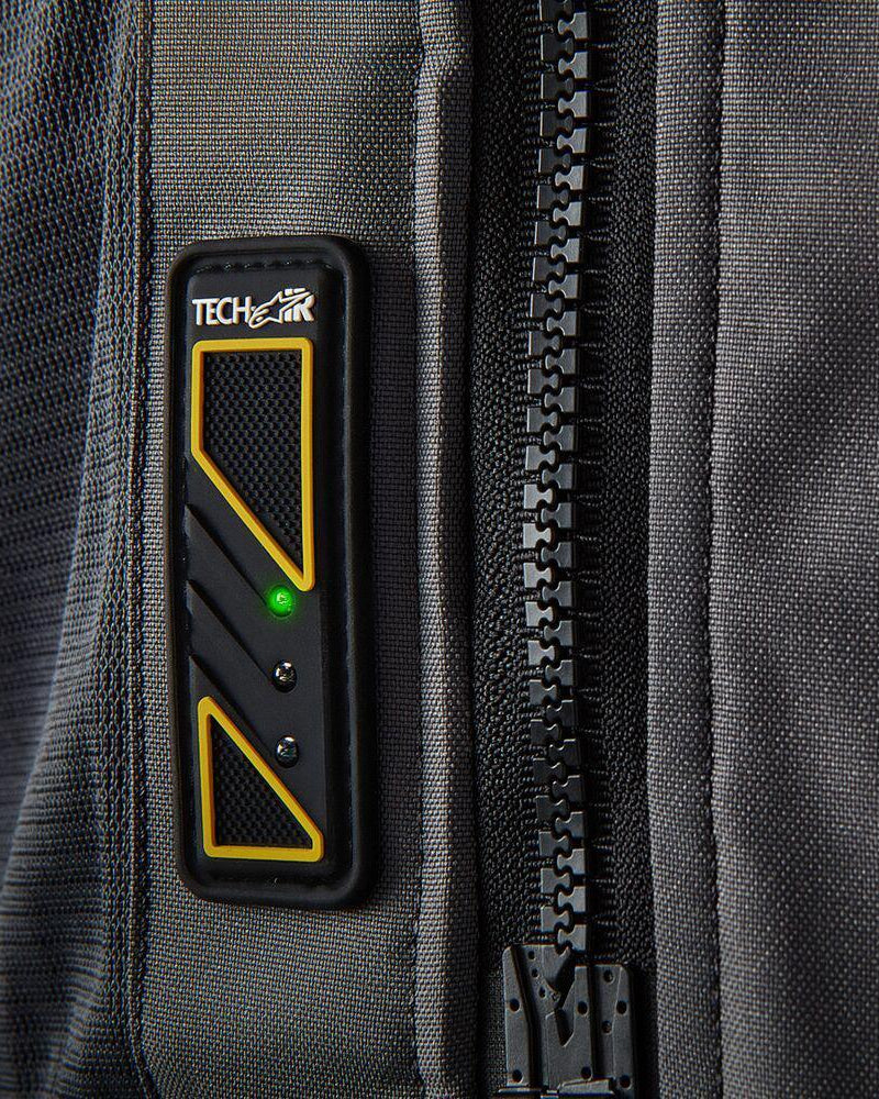 Display Led Tech-Air 5 su gilet in tessuto grigio scuro con luce verde accesa e grande cerniera nera, airbag moto.