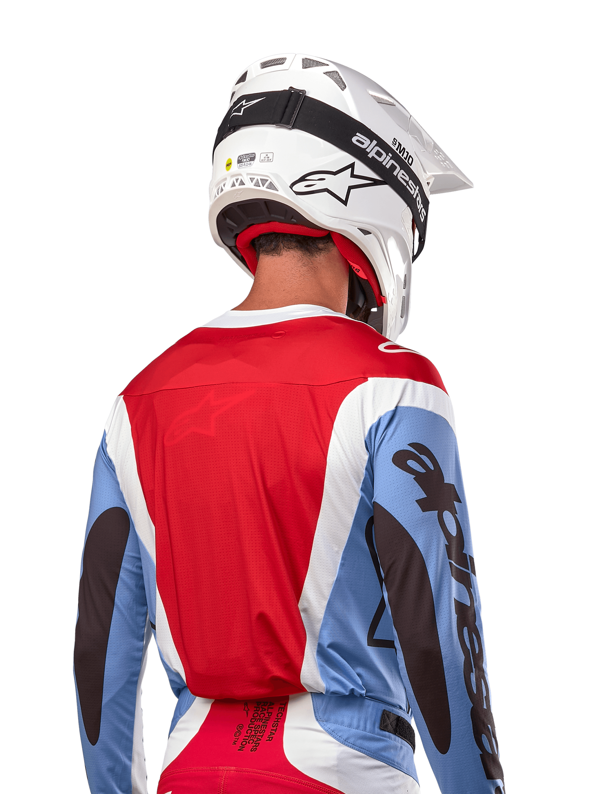 Alpinestars 2024 Techstar Ocuri Jersey, maglia da motocross, azzurro, rosso Marte e bianco, vista posteriore del pilota con casco bianco coordinato e occhiali neri, presenta un audace branding nero sulle maniche e vestibilità race ergonomica per prestazioni fuoristrada