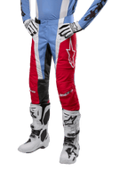 Alpinestars 2024 Techstar Ocuri Pants, pantaloni da motocross, azzurro, rosso Mars e bianco, indossati con jersey azzurro e stivali bianchi, con logo a stella sulla coscia e ginocchia rinforzate, equipaggiamento completo per corse fuoristrada