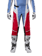 Alpinestars 2024 Techstar Ocuri Pants, pantaloni da motocross, azzurro, rosso Marte e bianco, vista frontale dalla vita in giù, abbinati a stivali e guanti da motocross bianchi e neri, attrezzatura tecnica per competizioni fuoristrada ad alte prestazioni
