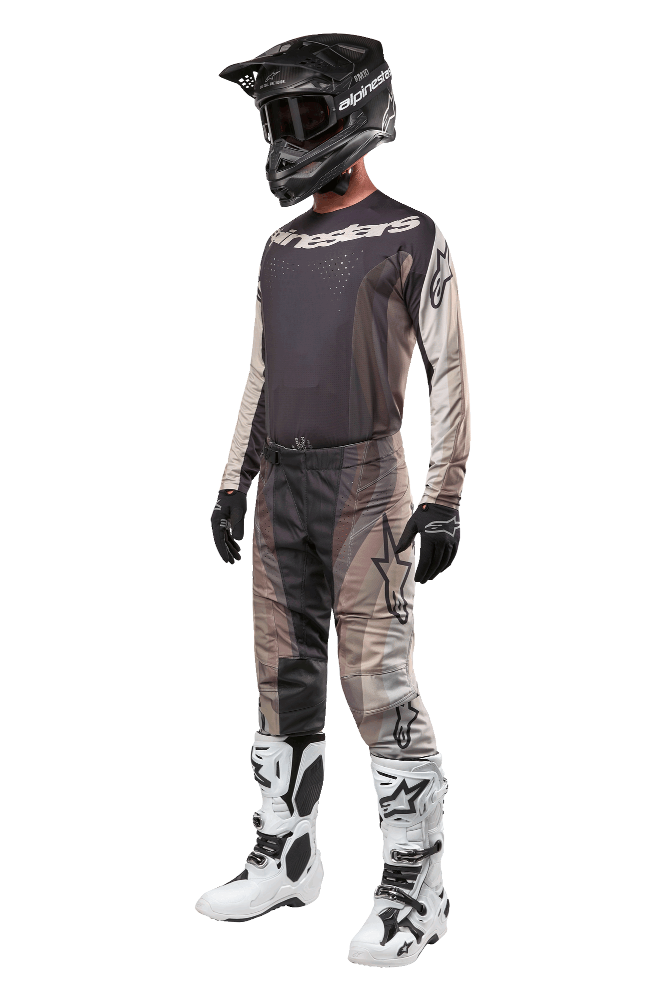 Pantaloni Alpinestars Techstar Pneuma 2024, pantaloni da motocross, Dark Sand Iron Dust Gray, indossati come parte di un set completo con maglia coordinata, casco nero, guanti neri e stivali bianchi, caratterizzati da motivi mimetici desertici tonali con grandi loghi.