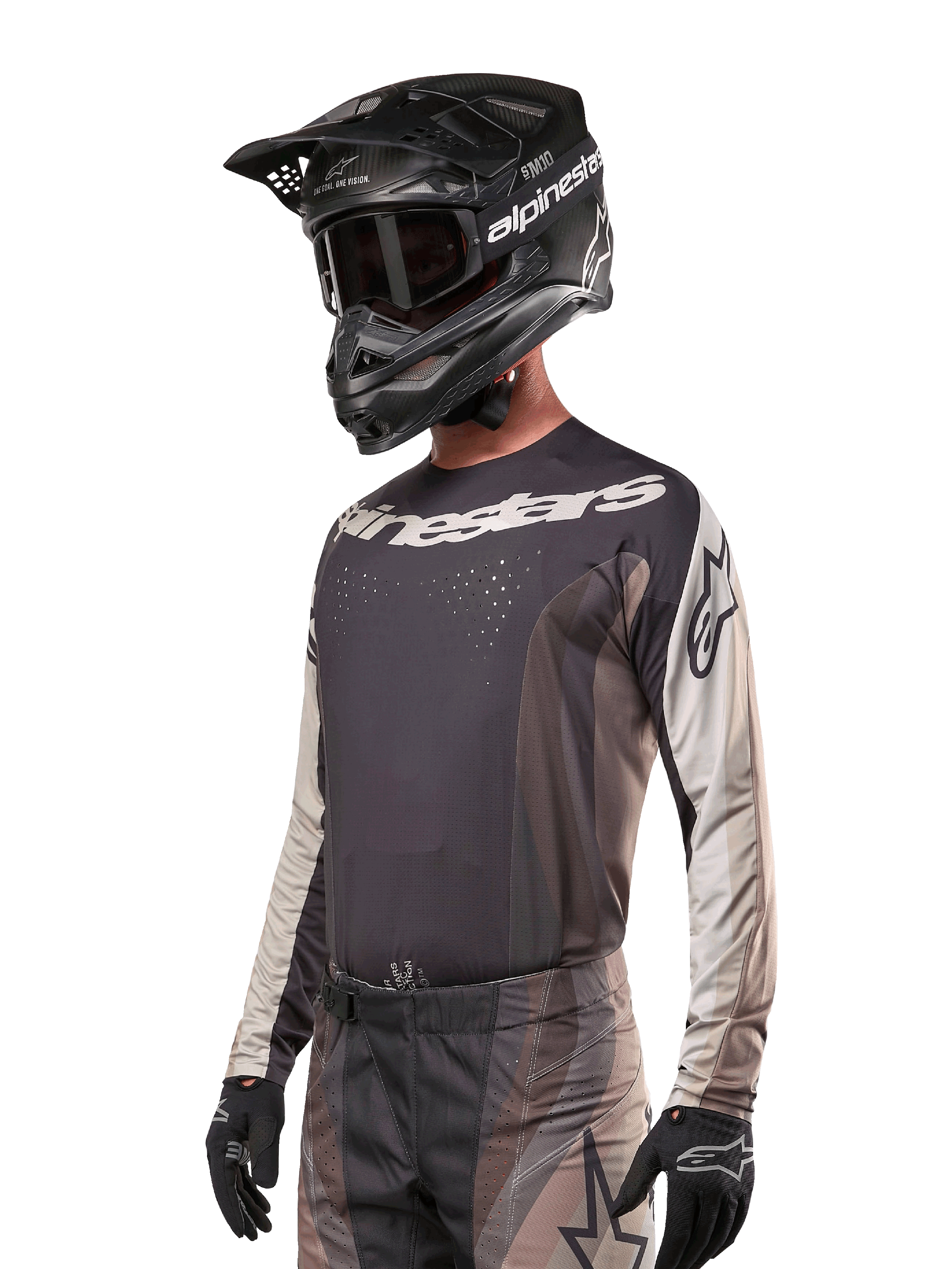 Alpinestars maglia Techstar Pneuma 2024, maglia da motocross racing, Dark Sand e grigio Iron Dust, maglia tecnica a maniche lunghe con perforazioni tagliate al laser e loghi bianchi, indossata con pantaloni coordinati e casco nero, vestibilità atletica per la guida fuoristrada.