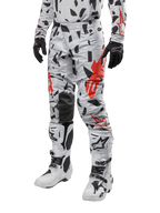 Alpinestars 2024 Techstar Rantera Pants, pantaloni da motocross, grigio Haze Gray Camo con motivo astratto nero e rosso, indossati con maglia coordinata, guanti neri e stivali da motocross bianchi, progettati per corse fuoristrada ad alte prestazioni