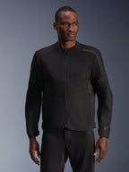 Modello che indossa la giacca Alpinestars C-1 Air in nero, giacca da moto contemporanea con ampi pannelli in rete tecnica e cerniera frontale completa, abbinata a pantaloni da guida neri coordinati, estetica urban lifestyle e per il pendolarismo