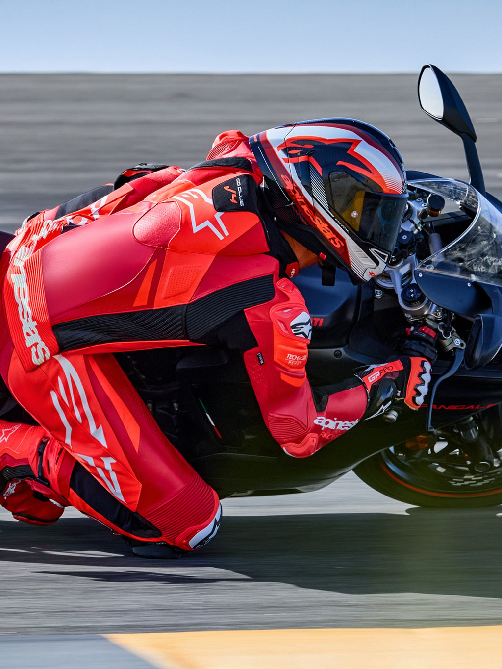 Alpinestars tuta in pelle GP Plus V4 Sprint 1 pezzo, rosso fluo e bianco, pronta per Tech-Air, pilota in piega su pista.