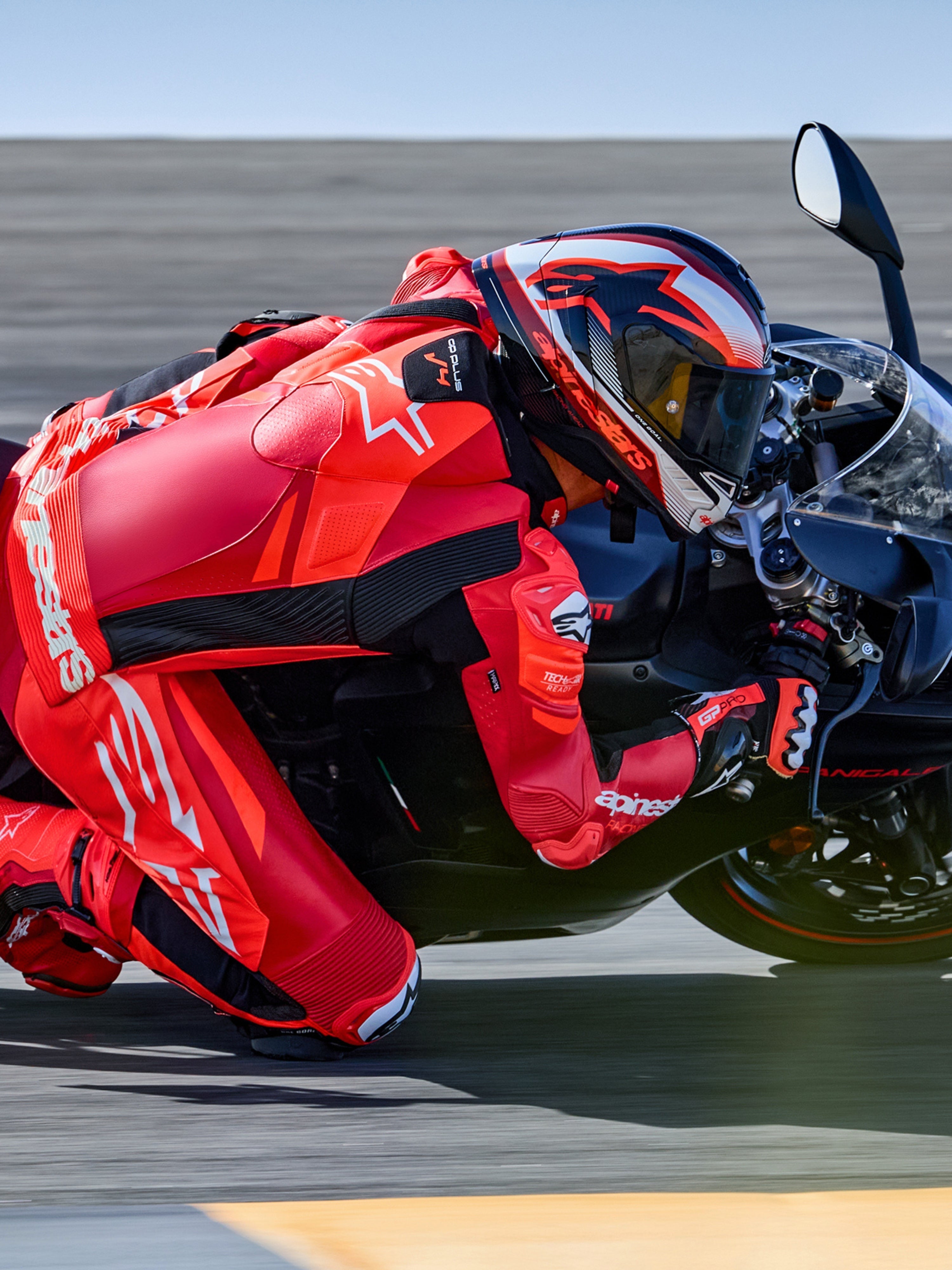 Alpinestars tuta in pelle GP Plus V4 Sprint 1 pezzo, rosso fluo e bianco, pronta per Tech-Air, pilota in piega su pista.