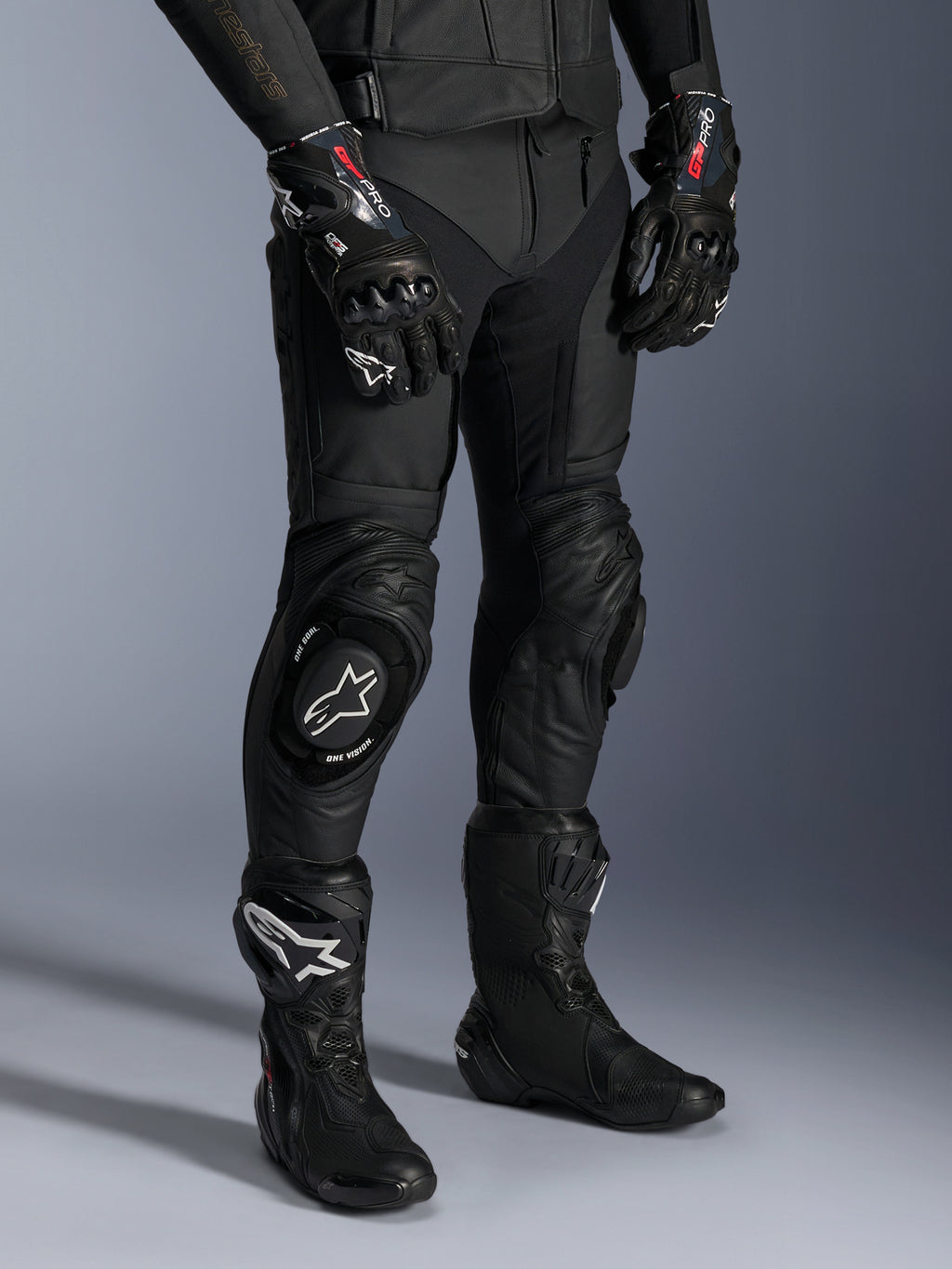 Alpinestars Missile V3, pantaloni da moto racing in pelle nera, indossati con guanti GP Pro e stivali da corsa tecnici, costruzione in pelle premium con saponette per ginocchio con logo bianco, estetica racing professionale per pista e strada