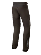 Alpinestars AST-1 V2 Waterproof Pants Long, pantaloni da moto in tessuto nero, vista posteriore con dettagli riflettenti e branding verticale sulla parte inferiore della gamba, abbigliamento tecnico resistente per tutte le stagioni