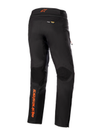Pantaloni Alpinestars AMT-10R Drystar® XF, nero con accenti arancioni, vista posteriore con logo Alpinestars arancione verticale sulla gamba sinistra, pannelli testurizzati sulle ginocchia e branding Kevlar e Matryx, pantaloni tecnici da moto adventure touring