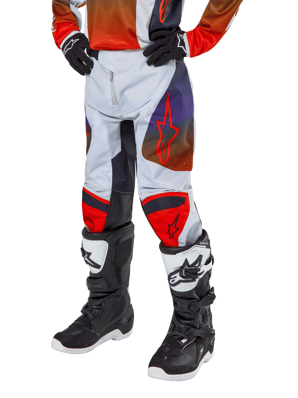 Alpinestars pantaloni Youth Racer Hoen 2024, pantaloni da motocross per ragazzi, grigio chiaro con accenti arancione acceso e nero, con loghi a stella rossi sulle cosce e pannelli rossi sulle ginocchia, indossati con stivali bianchi e neri, design resistente per corse fuoristrada