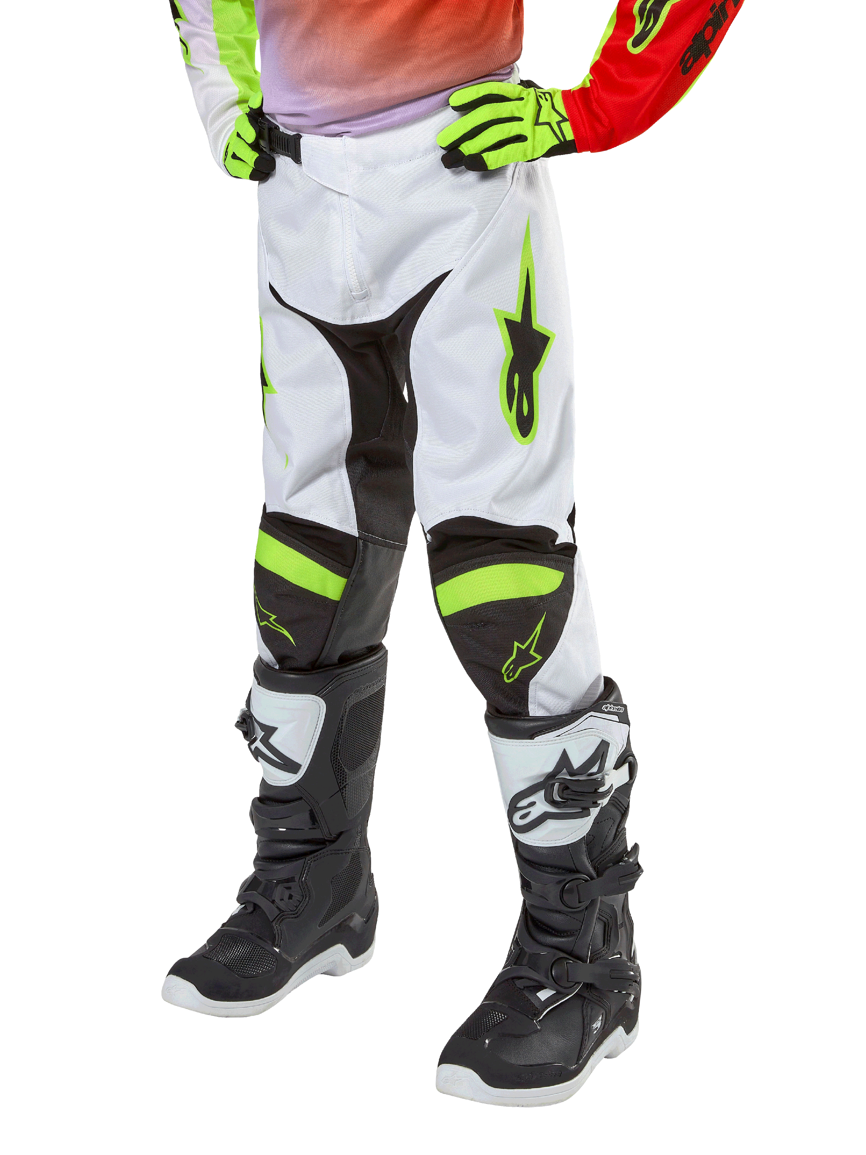 Alpinestars Youth 2024 Racer Lucent Pants, pantaloni da motocross, bianco, rosso neon e giallo fluo, vista della parte inferiore con pannelli elasticizzati neri e accenti neon, indossati con stivali da gara bianchi e neri e guanti giallo neon, abbigliamento tecnico da fuoristrada per ragazzi