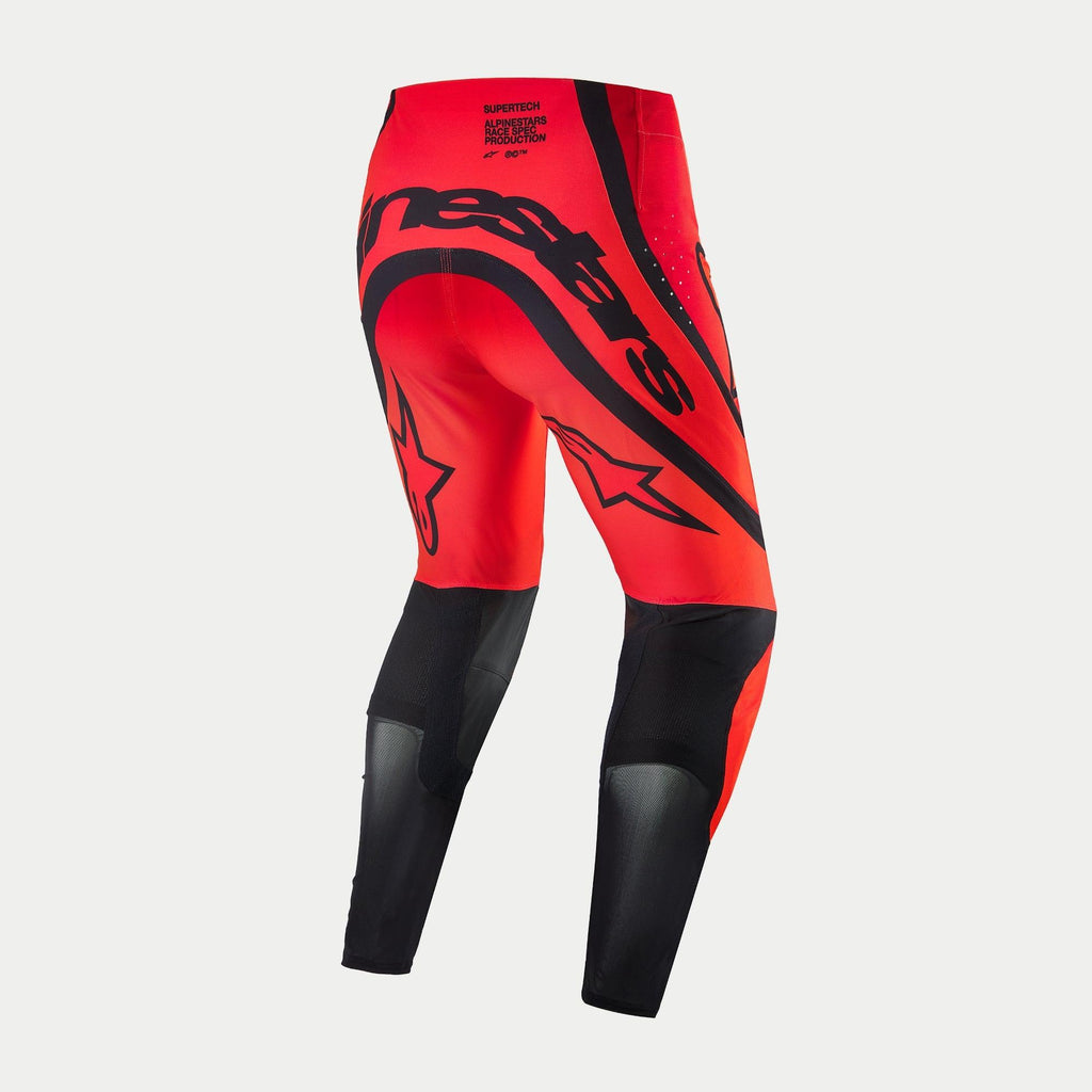 Alpinestars Supertech Ember LE Pants, pantaloni da motocross, rosso fluo e rosso brillante con accenti neri, vista posteriore con vistoso marchio Alpinestars nero sulla seduta, loghi a stella sulle cosce e pannelli tecnici in mesh sulla parte inferiore delle gambe.