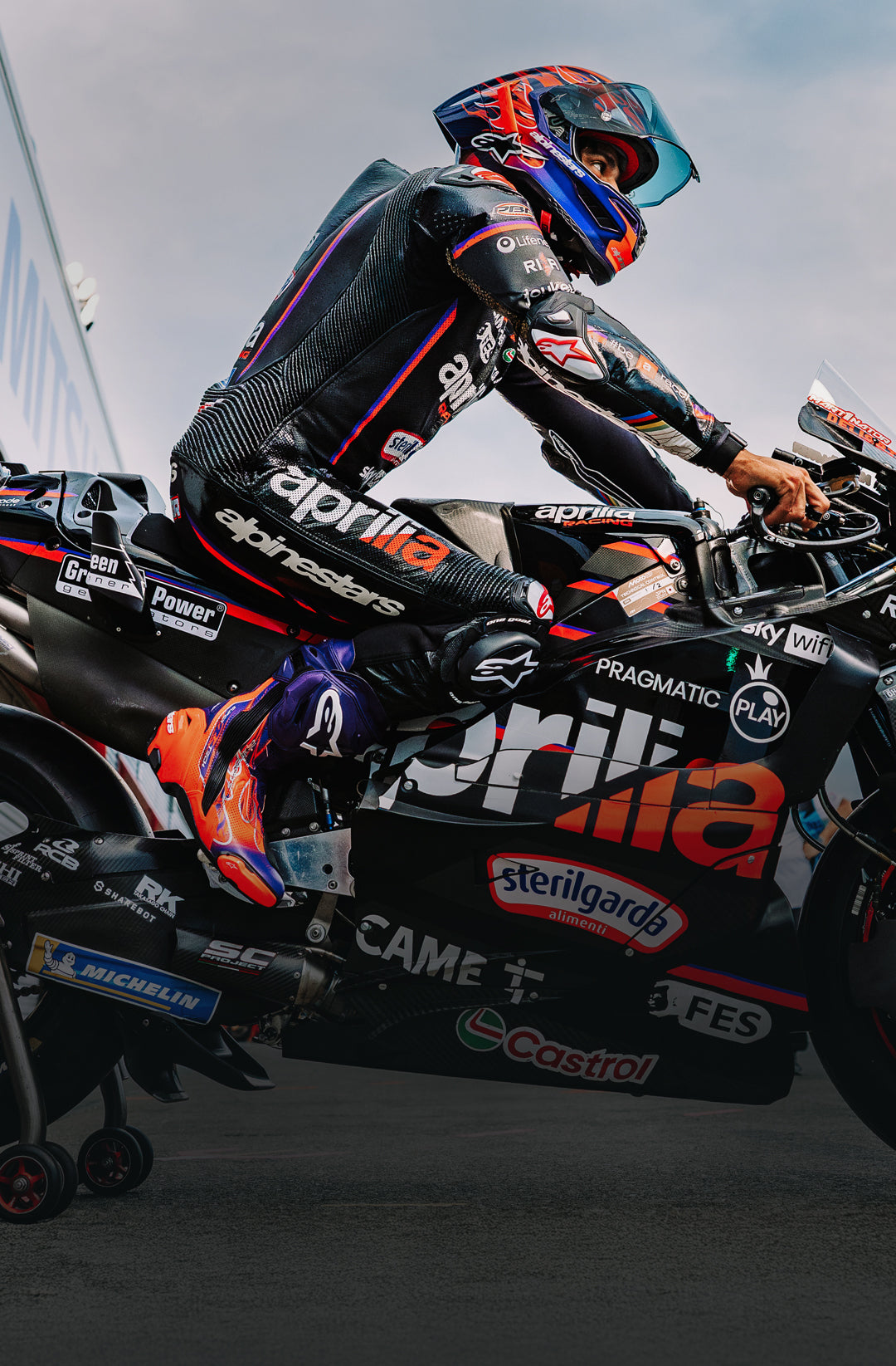 Motorcycle racer in action with sponsor logos on a track