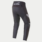 Alpinestars 2021 Techstar Phantom Pants, pantaloni da motocross, nero e bianco, vista posteriore con marchio ASTARS bianco sulla vita e sulla coscia laterale, pannelli in mesh testurizzato color carbone sulle gambe, design con vestibilità racing.